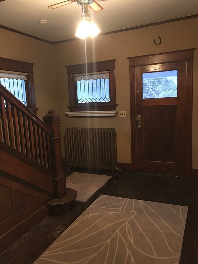 Vestíbulo, entrada principal al porche. Se aprecia la magnífica carpintería que se ha conservado en esta hermosa escalera. Ventanas de vidrieras emplomadas, con contraventanas exteriores para mayor aislamiento. - 1545 S 13th St