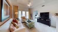 This single-floor residence offers a thoughtfully designed layout that balances comfort and functionality throughout. The living room serves as the heart of the home, featuring a tray ceiling with a ceiling fan, plush carpeting, and French doors that flood the space with natural light and provide access to an outdoor area. Bold accent walls in warm terracotta and sage green tones lend each room a distinct character and visual warmth.

The galley-style kitchen is efficiently organized with light wood cabinetry, white countertops, a double-basin sink, and white appliances including a dishwasher and refrigerator. Adjacent to the kitchen, the dining area accommodates a round table beneath a pendant light fixture, accented by a large wall mirror that enhances the sense of space.

The bedrooms are generously sized, each featuring soft carpeting, large windows with serene outdoor views — including a picturesque waterfront scene — and ample closet space, including mirrored sliding closet doors in one room. One bedroom benefits from a connected bathroom and walk-in closet.

Both bathrooms are finished with tile flooring, white vanity cabinetry, and soaking tubs with shower combinations. The overall ambiance is warm and inviting, with cohesive design choices that create a comfortable, livable environment throughout.