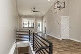 This thoughtfully designed two-story home offers a comfortable and functional layout across two main floors and an unfinished basement. The main level welcomes you with a dedicated entrance and soaring ceilings in the living area, accented by warm light hardwood flooring, recessed lighting, and a stylish geometric pendant chandelier. The galley-style kitchen is a standout feature, boasting white shaker cabinetry, granite countertops, stainless steel appliances, a subway tile backsplash, and a walk-in pantry — all set atop hardwood floors.

The upper floor is home to both bedrooms, two full bathrooms, and multiple closets. The primary bedroom suite includes a well-appointed en-suite bathroom with dual granite vanities, white cabinetry, brushed nickel fixtures, a glass-enclosed shower, and direct access to a spacious walk-in closet with wire shelving. The secondary bedroom features plush carpet, vaulted ceilings, and a bright window. A staircase with a sleek metal railing connects the floors, flanked by hallways that provide excellent flow. The unfinished basement offers generous open space with exposed joists and a concrete floor, presenting strong potential for future customization.