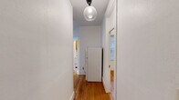 Located at 11 Tetlow St in Boston's Fenway neighborhood, this one-bedroom, one-bathroom unit offers a well-organized layout across a single floor. Warm hardwood floors run throughout the space, lending a classic New England character to every room. The living room is a standout feature, highlighted by a charming bay window that frames neighborhood views and floods the room with natural light, complemented by a cast-iron radiator that adds vintage appeal. A central hallway connects the rooms efficiently, with two closets providing practical storage. The bedroom is a comfortable, well-proportioned space with multiple windows fitted with blinds and its own cast-iron radiator, ensuring warmth and privacy. The kitchen is equipped with warm oak cabinetry, granite-style countertops, and a window that brings in additional natural light, making it a functional and inviting space for cooking. The bathroom features classic white subway tile surrounding a full bathtub and shower, with a window for ventilation. A globe pendant light fixture in the hallway adds a modern touch to the unit's traditional aesthetic. Two closets offer ample storage throughout the home.