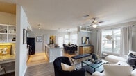 This well-appointed 2-bedroom, 2-bathroom single-story residence in Houston, TX (77040) offers a thoughtfully designed open-concept floor plan that seamlessly connects the living, dining, and kitchen areas. The living room features wood-style flooring, crown molding, a ceiling fan, and large windows that invite an abundance of natural light, creating a bright and welcoming atmosphere. The kitchen is equipped with granite countertops, white cabinetry, black appliances including a refrigerator and range, tile flooring, and a center island that doubles as a breakfast bar — ideal for both cooking and casual dining. The adjacent dining area accommodates a full-sized table and benefits from a large window with outdoor views. The primary bedroom is a serene retreat with plush carpeting, a ceiling fan, and a private en-suite bathroom featuring a walk-in shower, separate soaking tub, tile flooring, and a spacious walk-in closet with built-in shelving. The second bedroom also features carpeting, a ceiling fan, and generous window placement. Additional highlights include an in-unit laundry area with a full-size washer and dryer, and a dedicated hallway connecting all living spaces efficiently. The overall ambiance is contemporary and polished, with neutral tones and modern accents throughout.