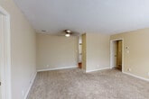 Located at 4003 S Broad St in Scottsboro, Alabama, this single-story home offers four bedrooms and two full bathrooms within a practical and well-organized floor plan. The layout flows efficiently through a central hallway connecting the living areas, bedrooms, and shared spaces.

The bedrooms feature neutral beige walls, plush wall-to-wall carpeting, and ceiling fans with integrated lighting. The generously sized primary bedroom provides ample space and comfort. Additional bedrooms each include windows fitted with blinds, allowing natural light while maintaining privacy, and closet access for storage.

The kitchen is outfitted with white cabinetry, a double-basin sink, a full-size electric range, and a refrigerator, all set above warm hardwood-style flooring. The layout provides efficient counter and storage space suitable for everyday use.

Both bathrooms feature clean, white tub-shower combinations with straightforward, functional fixtures set against warm-toned walls. A dedicated laundry area and built-in shelving provide additional utility and storage. The home also includes a water heater housed in its own utility space with overhead shelving.

Throughout the home, textured ceilings, clean white trim, and a consistent warm neutral color palette create a cohesive, understated ambiance well-suited for comfortable everyday living.