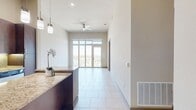 This 800 square foot apartment in Fiori On Vitruvian Park offers a thoughtfully designed living space. The heart of the home is the gourmet kitchen, showcasing rich wood cabinetry, granite countertops, and stainless steel appliances. Pendant lighting adds a touch of elegance, while under-cabinet lighting provides functional task lighting.

The open-concept layout seamlessly connects the kitchen to the living and dining areas, creating an ideal space for entertaining. Large windows flood the apartment with natural light and offer expansive city views, enhancing the sense of space and connection to the outdoors.

The bedroom, measuring 160 square feet, features plush carpeting and a large window, creating a cozy retreat. A sliding door leads to a walk-in closet, providing ample storage space. The bathroom boasts a double vanity with granite countertops, matching the kitchen's aesthetic, and is finished with modern fixtures and tilework.

Throughout the apartment, neutral tones and high-end finishes create a sophisticated ambiance. The combination of tile and carpet flooring adds texture and defines different living areas. With its modern amenities and thoughtful design, this apartment offers a perfect blend of style and functionality in the heart of Addison, Texas.