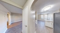 Located at 1601 E Katie Ave in Las Vegas, NV, this single-floor, 2-bedroom, 3-bathroom residence offers a well-designed layout across a comfortable footprint. The interior greets you with a hallway featuring a distinctive arched entryway that leads into the combined kitchen and living area. Wood-look plank flooring runs throughout the main living spaces, complementing the neutral, warm-toned walls and textured ceilings. The living room benefits from natural light through arched windows and includes a ceiling fan for year-round comfort, with a sliding glass door providing additional brightness. The kitchen is outfitted with white shaker-style cabinetry, laminate countertops, stainless steel appliances including a refrigerator, gas range, and dishwasher, as well as a peninsula that adds functional counter space. Both bedrooms are carpeted and well-proportioned, with the generously sized primary bedroom offering ample room. Three bathrooms serve the unit, including one with a standalone glass-enclosed shower and another with a full tub-shower combo, white vanity, and wood-look tile flooring. A dedicated closet adds practical storage. The overall aesthetic is clean and modern, with consistent finishes throughout.