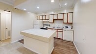 Located at 7277 NE Dunwoody Rd in Atlanta, GA, this one-bedroom, two-bathroom unit offers a practical and comfortable layout across a single floor. The kitchen is a standout feature, equipped with white cabinetry accented by rich wood trim, recessed lighting, and a full suite of appliances including a refrigerator, electric range, dishwasher, and microwave. A large peninsula island provides additional counter space and serves as a natural divider between the kitchen and the living area. Durable hardwood-style flooring runs through the kitchen and bathroom areas, adding warmth and easy maintenance.

The bedroom is a comfortable retreat, carpeted for added softness, and features crown molding, a ceiling fan with light fixture, and a window with blinds that frames leafy outdoor views, filling the room with natural light. The two bathrooms include a vanity with mirror and wood-accented cabinetry, hardwood-style flooring, and a tiled tub-shower combination with chrome fixtures. A dedicated closet provides convenient storage. Throughout the unit, neutral cream-toned walls and crown molding lend a clean, cohesive aesthetic that makes the space feel bright and welcoming.