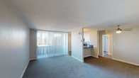 Located at 3950 Leland in San Diego, this single-floor unit offers a well-designed layout that balances comfort and functionality. The open living area is generously sized, featuring plush carpeting and floor-to-ceiling vertical blinds that allow abundant natural light to fill the space while providing privacy. A pass-through peninsula connects the living area to the kitchen, creating a seamless flow between the two spaces. The kitchen is outfitted with crisp white cabinetry, dark quartz countertops, and stainless steel appliances including a range, over-the-range microwave, and refrigerator, offering both style and practicality. The unit includes multiple bedrooms, each carpeted and featuring windows with outdoor views of the surrounding San Diego landscape, filling the rooms with natural light. A ceiling fan is present in one of the bedrooms, adding comfort. The unit is served by two bathrooms, each featuring white cabinetry with dark countertops, undermount sinks, updated fixtures, and well-lit vanity mirrors. One bathroom includes a walk-in shower, while the other offers a shower-tub combination. Wood-style flooring is found in the bathrooms and kitchen areas, providing a clean contrast to the carpeted living and sleeping spaces.