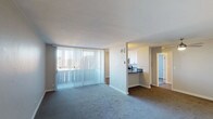 Located at 3950 Leland in San Diego, this single-floor unit offers a well-designed layout that balances comfort and functionality. The open living area is generously sized, featuring plush carpeting and floor-to-ceiling vertical blinds that allow abundant natural light to fill the space while providing privacy. A pass-through peninsula connects the living area to the kitchen, creating a seamless flow between the two spaces. The kitchen is outfitted with crisp white cabinetry, dark quartz countertops, and stainless steel appliances including a range, over-the-range microwave, and refrigerator, offering both style and practicality. The unit includes multiple bedrooms, each carpeted and featuring windows with outdoor views of the surrounding San Diego landscape, filling the rooms with natural light. A ceiling fan is present in one of the bedrooms, adding comfort. The unit is served by two bathrooms, each featuring white cabinetry with dark countertops, undermount sinks, updated fixtures, and well-lit vanity mirrors. One bathroom includes a walk-in shower, while the other offers a shower-tub combination. Wood-style flooring is found in the bathrooms and kitchen areas, providing a clean contrast to the carpeted living and sleeping spaces.