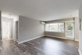 This well-appointed one-bedroom, one-bathroom residence at 4820 Kenmore Ave in Alexandria, Virginia offers a thoughtfully designed single-floor layout with modern updates throughout. The open living and dining areas feature durable wood-look flooring in a warm gray tone, neutral gray walls, and large windows that invite abundant natural light. A wall-mounted mini-split unit provides efficient climate control in the living area. The galley-style kitchen is a standout feature, showcasing white shaker cabinetry, gray quartz countertops, a classic white subway tile backsplash, and a full suite of stainless steel appliances including a gas range, microwave, dishwasher, and refrigerator. The spacious primary bedroom offers soft carpeting, a generous window with outdoor views, and a wall-mounted climate unit. A dedicated closet provides ample storage, complemented by three closets throughout the unit. The bathroom features a pristine white subway tile tub surround and clean, modern finishes. Hallways connect the rooms with continuity, and an in-unit laundry area adds everyday convenience. A private outdoor space accessible from the living area rounds out this well-equipped Alexandria residence.