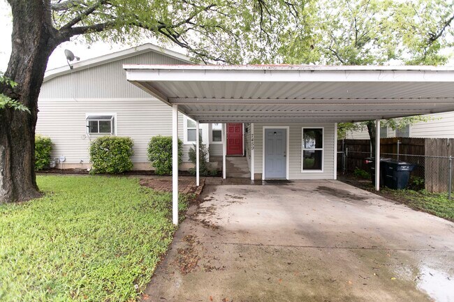 Estacionamiento cubierto. La puerta roja es la entrada principal. La puerta azul es la entrada al apartamento. - 7459 Mohawk Ave