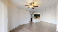 This single-story 2-bedroom, 3-bathroom residence in Lake Charles, Louisiana offers a practical and well-finished layout designed for comfortable living. The open-concept living area features wood-look laminate flooring and a ceiling fan, creating a bright and airy atmosphere that flows seamlessly into the kitchen. The kitchen is a standout feature, equipped with dark espresso cabinetry, granite countertops, a subway tile backsplash, black appliances including a range and built-in microwave, and a peninsula with an integrated sink — ideal for both cooking and casual dining. Each bedroom is carpeted and includes a ceiling fan, with sliding glass doors that open to an outdoor area, allowing natural light and outdoor views. The bathrooms are consistently finished with granite-topped dark vanities, wood-look flooring, and tub-shower combinations with grab bars. A dedicated in-unit laundry room accommodates a full-size washer and dryer side by side. The hallway connects all rooms efficiently within the compact yet thoughtfully designed floor plan. Clean white walls and consistent finishes throughout give the space a cohesive and well-maintained appearance.