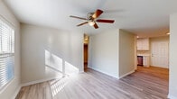 This 750 square foot single-story home in Gastonia, NC offers a blend of comfort and modern design. The property features two bedrooms, including a primary bedroom of 140 square feet, and one bathroom. Throughout the home, light wood-toned vinyl flooring creates a cohesive and contemporary look.

The living spaces are bright and airy, with large windows allowing natural light to flood the rooms. Ceiling fans with light fixtures are installed in multiple rooms, enhancing both lighting and air circulation. The kitchen is a highlight, boasting sleek white cabinetry, stainless steel appliances, and light-colored countertops. It's equipped with modern amenities including a built-in microwave and dishwasher.

The bathroom is compact yet functional, featuring a pedestal sink, toilet, and a shower/tub combination. Two closets provide additional storage space. The overall neutral color palette, dominated by whites and light tones, creates a clean and spacious atmosphere throughout the home.

This property is ideal for small families, couples, or individuals looking for a low-maintenance, stylish living space in a convenient location.
