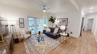 Located at 940 Israel Rd SW in Tumwater, Washington, this ground-floor unit offers a thoughtfully designed single-level layout with modern finishes and a bright, welcoming atmosphere throughout. The living room is a standout space, featuring vaulted ceilings, light-toned hardwood-style flooring, and a ceiling fan that adds to the airy feel. Large sliding glass doors open to an outdoor patio, filling the room with natural light and providing a seamless indoor-outdoor connection. The kitchen is well-appointed with dark espresso cabinetry, crisp white countertops, a classic subway tile backsplash, and a full suite of stainless steel appliances. A central island with seating makes it ideal for both casual dining and entertaining. Two bedrooms provide comfortable retreats, each with large windows that invite natural light and views of the surrounding greenery. The two bathrooms mirror the kitchen's design aesthetic, featuring dark wood vanities, light countertops, and hardwood-style flooring. One bathroom includes a full soaking tub with shower, while the second serves as a well-proportioned secondary bath. The consistent use of neutral tones, quality materials, and modern fixtures gives the entire space a cohesive and polished character.