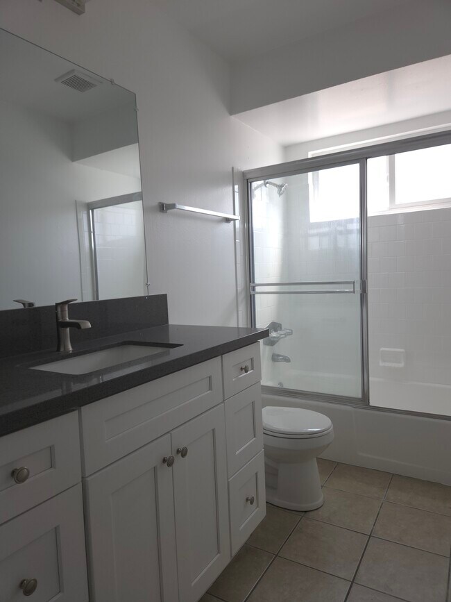 Baño de pasillo con encimera de cuarzo y gabinetes estilo Shaker. - 3455 Elm Ave