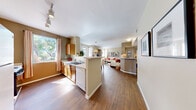 Located in Las Vegas, NV, this well-appointed 2-bedroom, 2-bathroom residence offers a thoughtfully designed single-level layout. The open-concept living area seamlessly connects the kitchen, dining space, and living room, all unified by warm wood-style flooring that extends throughout the main areas. The kitchen features warm wood cabinetry, a breakfast bar with seating, track lighting, and a window that draws in natural light — making it both functional and inviting. The living room is highlighted by a built-in media niche and large windows that brighten the space. Both bedrooms are carpeted and generously sized, each benefiting from bay-style windows that frame outdoor views and fill the rooms with natural light. The primary bedroom includes a spacious walk-in closet with built-in wire shelving. Each of the two bathrooms is outfitted with a full tub-shower combination, a wide vanity with ample counter space, a large mirror, and wood-accented cabinetry. Additional features include a dedicated laundry area and a private patio. The neutral warm-beige color palette throughout creates a cohesive, comfortable ambiance well-suited to everyday living.