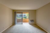 Located in San Jose, CA, this single-floor residence offers two bedrooms and two bathrooms within a well-organized, functional layout. The living room is generously sized, featuring soft wall-to-wall carpeting, neutral warm-toned walls, and a sliding glass door that opens to an outdoor area, flooding the space with natural light and providing views of the surrounding greenery. A baseboard heating unit and wall-mounted A/C ensure year-round comfort.

The kitchen is designed with practicality in mind, featuring granite countertops, a pass-through breakfast bar that opens to the living and dining area, white cabinetry, and standard appliances including a refrigerator, range, and microwave. Wood-style flooring runs through the kitchen and entry areas, providing a clean contrast to the carpeted living spaces.

The primary bedroom is notably spacious, complete with plush carpeting, natural light from a large window, a baseboard heater, and a sliding-door closet with built-in shelving for organized storage. The en-suite bathroom features a granite-topped vanity, white shaker-style cabinetry, a glass-enclosed shower, and wood-style flooring. The second bathroom offers a full bathtub and granite vanity. A central hallway connects all rooms, providing a cohesive and easy-to-navigate floor plan throughout.