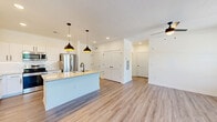 Located at 200 Aycock Avenue in Monroe, GA, this thoughtfully designed one-bedroom, one-bathroom unit offers a comfortable and efficient single-floor layout. The open-concept kitchen and living area forms the heart of the home, anchored by a striking central island with a granite countertop, undermount sink with a matte black faucet, and built-in dishwasher. Crisp white shaker cabinetry lines the kitchen walls, complemented by a subway tile backsplash and a full suite of stainless steel appliances. Pendant lighting with warm bronze tones hangs above the island, adding a modern touch. Durable wood-look flooring runs throughout the space, tying each room together seamlessly. The living area is bright and open, with multiple windows and a glass-paneled exterior door that invite natural light and outdoor views of the surrounding greenery. A ceiling fan adds comfort to both the living area and the spacious primary bedroom, which features a generously sized window with views of the outdoors. The bathroom is clean and functional, offering a granite vanity countertop, a tub-shower combination with white tile surround, and wood-look flooring. A dedicated closet provides practical storage. The overall aesthetic is fresh, modern, and move-in ready.