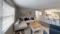 Located at 1400 16th St N in Saint Petersburg, Florida, this single-story space offers a cohesive, neutral aesthetic throughout with warm wood-look flooring and textured ceilings that add subtle character to each room.

The living area is generously proportioned, featuring multiple windows fitted with horizontal blinds and curtain panels that allow for ample natural light. The open layout flows seamlessly into the kitchen, which is equipped with stainless steel appliances, white cabinetry, light granite-style countertops, and a peninsula that doubles as a casual dining space with bar seating. A skylight above the kitchen adds an additional source of natural brightness.

The primary bedroom is a well-sized retreat with wood-look flooring, a large window, and a calm, neutral color palette. It connects to a bathroom featuring a white vanity, modern brushed nickel fixtures, and classic white subway tile in the shower area. A second, cozier bedroom with carpeting offers flexible use as a guest room or office space.

Overall, the space presents a clean, updated interior with a practical layout suited for comfortable everyday living in the heart of St. Petersburg.