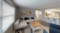 Located at 1400 16th St N in Saint Petersburg, Florida, this single-story space offers a cohesive, neutral aesthetic throughout with warm wood-look flooring and textured ceilings that add subtle character to each room.

The living area is generously proportioned, featuring multiple windows fitted with horizontal blinds and curtain panels that allow for ample natural light. The open layout flows seamlessly into the kitchen, which is equipped with stainless steel appliances, white cabinetry, light granite-style countertops, and a peninsula that doubles as a casual dining space with bar seating. A skylight above the kitchen adds an additional source of natural brightness.

The primary bedroom is a well-sized retreat with wood-look flooring, a large window, and a calm, neutral color palette. It connects to a bathroom featuring a white vanity, modern brushed nickel fixtures, and classic white subway tile in the shower area. A second, cozier bedroom with carpeting offers flexible use as a guest room or office space.

Overall, the space presents a clean, updated interior with a practical layout suited for comfortable everyday living in the heart of St. Petersburg.