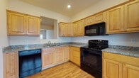 Located at 430 Silver Maple Ridge in Charleston, WV, this three-floor property offers a well-designed layout with consistent finishes throughout. The kitchen is a functional centerpiece, featuring light maple cabinetry with raised-panel doors, granite countertops, hardwood-style flooring, and a full suite of black appliances including a range, over-the-range microwave, dishwasher, and refrigerator. A pass-through opening connects the kitchen to adjacent living areas, enhancing the sense of openness.

The main living area is generously proportioned, with warm hardwood-style flooring, rich wood baseboards, and neutral walls that create a bright, welcoming atmosphere. A staircase with wooden handrails connects the floors, and the lower level features a drop ceiling, carpeted flooring, and access to a spacious garage area with a concrete floor.

Bedrooms are carpeted and receive natural light through blinds-fitted windows. Bathrooms are finished with tile flooring, wood-toned vanity cabinetry, and tub-shower combinations. Throughout the property, warm-toned wood accents, neutral walls, and recessed lighting contribute to a cohesive and comfortable aesthetic across all three floors.