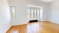 Located at 2425 Overlook Rd in Cleveland Heights, this 2-bedroom, 1-bathroom residence combines classic architectural charm with modern updates. Light wood-style flooring runs throughout the entire space, creating a cohesive and airy feel. The living room is bathed in natural light from a trio of windows and features a traditional cast-iron radiator, adding character to the clean, white-walled interior. An elegant arched doorway connects the living area to the kitchen, a thoughtfully designed galley-style space outfitted with white shaker cabinetry, matte black hardware, a dark subway tile backsplash, white countertops, and stainless steel appliances. Both bedrooms are well-proportioned and bright, each equipped with ceiling fans and generous closet space — the space includes four closets in total. The primary bedroom benefits from dual windows overlooking the surroundings. A connecting hallway provides convenient access throughout. The full bathroom features a soaking tub with shower, a grey vanity with an integrated sink, a framed mirror, and a window for natural ventilation. With four closets distributed across the layout, storage is plentiful. The unit's crisp white palette and modern finishes give it a fresh, move-in-ready appeal.