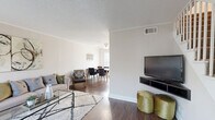 This two-bedroom, two-floor home offers a practical and well-appointed layout spread across two equally sized levels. The main floor features a bright living room with rich dark hardwood flooring, large windows that invite natural light, a textured ceiling, and a staircase leading to the upper level. The living area flows seamlessly into the dining room, which is accented by a ceiling fan with lighting, a large window, and stylish wall décor — creating a welcoming space for everyday dining and entertaining. Adjacent to the dining room is a galley-style kitchen equipped with ample white cabinetry, light countertops, a double sink, an electric range, a dishwasher, and a drop ceiling with a window and exterior door access.

Upstairs, the primary bedroom is generously proportioned, featuring dark hardwood floors, a ceiling fan, natural light from a window, and a dedicated walk-in closet. The second bedroom continues the same warm aesthetic with a ceiling fan and textured ceiling. Four closets throughout the home provide excellent storage capacity. The full bathroom is clean and minimal, featuring white tile surround in the tub/shower area. Neutral tones, consistent hardwood-style flooring, and ceiling fans throughout each room define the overall cohesive and comfortable character of this home.