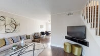 This two-bedroom, two-floor home offers a practical and well-appointed layout spread across two equally sized levels. The main floor features a bright living room with rich dark hardwood flooring, large windows that invite natural light, a textured ceiling, and a staircase leading to the upper level. The living area flows seamlessly into the dining room, which is accented by a ceiling fan with lighting, a large window, and stylish wall décor — creating a welcoming space for everyday dining and entertaining. Adjacent to the dining room is a galley-style kitchen equipped with ample white cabinetry, light countertops, a double sink, an electric range, a dishwasher, and a drop ceiling with a window and exterior door access.

Upstairs, the primary bedroom is generously proportioned, featuring dark hardwood floors, a ceiling fan, natural light from a window, and a dedicated walk-in closet. The second bedroom continues the same warm aesthetic with a ceiling fan and textured ceiling. Four closets throughout the home provide excellent storage capacity. The full bathroom is clean and minimal, featuring white tile surround in the tub/shower area. Neutral tones, consistent hardwood-style flooring, and ceiling fans throughout each room define the overall cohesive and comfortable character of this home.