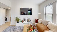 Located at 4166 Lindell Blvd in St. Louis's vibrant Central West End neighborhood, this thoughtfully designed one-bedroom, one-bathroom unit offers a well-appointed single-floor layout. Light hardwood flooring flows throughout, lending warmth and cohesion to every room.

The contemporary kitchen is a standout feature, showcasing light wood cabinetry, a marble-look tile backsplash, white quartz countertops, stainless steel appliances, and a gold-finish faucet. A peninsula with bar seating creates a natural transition into the living areas. The unit includes two distinct living spaces — one suited for lounging with large windows framing outdoor views, and a secondary area currently arranged as a home office with a louvered closet door and ample natural light.

The bedroom is bright and inviting, featuring multiple windows with city and treetop views, a ceiling fan, and light-toned walls that contribute to an airy feel. The bathroom is finished with large hexagonal floor tiles, a marble-surround soaking tub with shower, a wood-front vanity, and a gold curtain rod — balancing modern and warm design elements.

A connecting hallway with clean white doors ties the layout together efficiently, completing this stylish and functional urban residence.