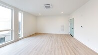 Located at 1635 N Fifth St in Philadelphia's vibrant North Fifth Street corridor, this well-appointed one-bedroom, one-bathroom unit offers a thoughtfully designed open-concept layout with clean, modern finishes throughout. Light wood-tone flooring runs continuously across the entire space, complementing the crisp white walls and creating a bright, airy atmosphere.

The combined kitchen and living area serves as the heart of the unit. The kitchen features white shaker-style cabinetry, a subway tile backsplash, stainless steel appliances including a refrigerator, range, and microwave, and a peninsula with a dark stone countertop that provides additional prep and seating space. Recessed lighting and a ceiling-mounted HVAC unit keep the area comfortable and well-lit.

Large windows in the living area and bedroom flood the unit with natural light and offer open views of the surrounding Philadelphia cityscape. The bedroom is a comfortable, well-proportioned room with its own sizable window and access to a dedicated walk-in closet outfitted with built-in shelving and double hanging rods.

The bathroom is finished with a dark stone vanity countertop, an undermount sink, a tiled shower-tub combo, and clean white walls, maintaining the modern aesthetic found throughout the unit.