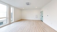 Located at 1635 N Fifth St in Philadelphia's vibrant North Fifth Street corridor, this well-appointed one-bedroom, one-bathroom unit offers a thoughtfully designed open-concept layout with clean, modern finishes throughout. Light wood-tone flooring runs continuously across the entire space, complementing the crisp white walls and creating a bright, airy atmosphere.

The combined kitchen and living area serves as the heart of the unit. The kitchen features white shaker-style cabinetry, a subway tile backsplash, stainless steel appliances including a refrigerator, range, and microwave, and a peninsula with a dark stone countertop that provides additional prep and seating space. Recessed lighting and a ceiling-mounted HVAC unit keep the area comfortable and well-lit.

Large windows in the living area and bedroom flood the unit with natural light and offer open views of the surrounding Philadelphia cityscape. The bedroom is a comfortable, well-proportioned room with its own sizable window and access to a dedicated walk-in closet outfitted with built-in shelving and double hanging rods.

The bathroom is finished with a dark stone vanity countertop, an undermount sink, a tiled shower-tub combo, and clean white walls, maintaining the modern aesthetic found throughout the unit.