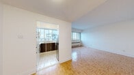 Located at 5550 Avenue Trent in Côte-Saint-Luc, unit 1506 is a well-organized single-floor residence defined by consistent design elements and practical layout throughout. Polished parquet flooring runs through the living areas and bedrooms, lending warmth and a classic character to the interior.

The living area is generously proportioned, with large windows that admit abundant natural light and offer open views of the surrounding neighbourhood. A baseboard heating unit runs beneath the windows, ensuring efficient climate control. The space connects naturally to the rest of the unit through a clear and logical floor plan.

The kitchen is configured in a U-shape, maximizing counter and storage space. It features dark wood cabinetry paired with white upper cabinets and light countertops, a double stainless steel sink, and a stainless steel range. A wide window above the sink fills the kitchen with daylight and neighbourhood views. The floor is finished in light ceramic tile.

The bedroom offers a comfortable footprint, parquet flooring, a large window with exterior views, and a sliding-door closet providing ample storage.

The bathroom is finished in clean white tile throughout, featuring a soaking tub with an overhead shower, a pedestal sink, and a large mirror, presenting a bright and functional space.