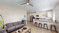 Located at 71 Palomar Avenue in San Luis Obispo, CA, this single-story, 5-bedroom, 2-bathroom home offers a well-designed layout suited for group living. The open-concept living, dining, and kitchen area forms the heart of the home, where light wood-look flooring, neutral walls, and a ceiling fan create a bright and airy atmosphere. The kitchen stands out with white shaker cabinets, a white subway tile backsplash, stainless steel appliances including a refrigerator, range, microwave, and dishwasher, and a spacious peninsula with a quartz countertop and bar seating — ideal for casual dining and entertaining. The living area provides comfortable communal space with natural light streaming through window blinds. The five bedrooms are efficiently sized, each featuring sliding frosted-glass closet doors and windows that bring in natural light. Bedrooms include carpeted or wood-look flooring and ample space for a bed and desk setup. The two bathrooms are finished with modern touches: one features a full glass-enclosed walk-in shower with large-format tile, while the other includes a white vanity with dark countertops and wood-look tile flooring. Additional spaces include a laundry room, utility room, hallway, and closet, rounding out this functional and move-in-ready home.