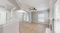 Located at 17671 Addison Rd in Dallas, TX, this single-floor, one-bedroom, one-bathroom home offers a well-designed layout with modern finishes throughout. Light wood-tone flooring flows seamlessly across all rooms, creating a cohesive and inviting ambiance. The open-concept living and kitchen area is anchored by an elegant arched passageway, crown molding, and a ceiling fan. A white-surround fireplace and multiple windows with natural light give the living area a warm, airy feel. The kitchen is well-appointed with white shaker-style cabinetry, light quartz countertops, a tile backsplash, and a full suite of stainless steel appliances including a dishwasher, range, and microwave. A peninsula counter provides additional workspace and casual dining potential. The bedroom is comfortably sized, featuring a ceiling fan, natural light from dual windows, and direct access to both a dedicated closet and the bathroom. The bathroom includes a soaking tub with tile surround, a single-sink vanity with white cabinetry, and wood-tone flooring. A dedicated laundry room with side-by-side washer and dryer adds everyday convenience. The hallway connects all spaces efficiently, completing this thoughtfully laid-out home.