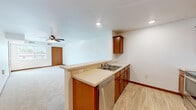 Located at 19568 Station St in Big Lake, MN, this single-floor residence offers three bedrooms and two bathrooms within a thoughtfully arranged floor plan. The kitchen serves as a central hub of the home, featuring warm medium-toned wood cabinetry, light countertops, a peninsula with a double-basin sink, and a full suite of stainless steel appliances including a refrigerator, range, microwave, and dishwasher. Light wood-look flooring runs throughout the kitchen, providing a clean, durable surface. The kitchen opens directly to the living room, which is finished with plush carpet and a ceiling fan, creating a comfortable and connected common area. The primary bedroom is a well-proportioned space with carpet flooring, a large window that admits natural light, and a dedicated closet. The additional bedrooms are similarly carpeted and offer versatile layouts suited for various uses. Both bathrooms are finished with wood-toned vanity cabinetry, light countertops, wood-look tile flooring, and one includes a full soaking tub. Consistent warm wood door and baseboard trim details are carried throughout the home, lending a cohesive and tidy aesthetic. The overall design is practical and clean, providing a comfortable living environment in a residential Big Lake neighborhood.