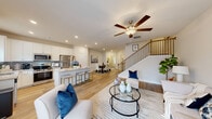Located at 2367 Whitburn Road in Lawrenceville, GA, this well-appointed two-story home offers three bedrooms and three bathrooms across two thoughtfully designed floors. The main level sets a welcoming tone with a bright, open-concept layout connecting the living room, dining area, and kitchen. Light hardwood-style flooring flows throughout, complemented by recessed lighting and a ceiling fan in the living area. The kitchen is a standout feature, showcasing white shaker cabinets, granite countertops with a tile backsplash, stainless steel appliances including a gas range, built-in microwave, and French door refrigerator, plus a center island with bar seating. The dining area accommodates a full-sized table and sits adjacent to the staircase, which features elegant wood treads and black iron balusters. A welcoming entrance with crown molding detail leads naturally into the main living spaces. Upstairs, the more spacious floor hosts all three bedrooms, including a generously sized primary suite with an en-suite bathroom featuring granite vanity counters, a glass-enclosed shower, and wood-look flooring. Additional bedrooms are finished with plush carpet. A dedicated laundry room and a walk-in closet with wire shelving add practical convenience to the upper level.
