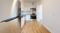 Located at 2570 Kingston Rd, Suite 305 in Toronto's Kingston Road corridor, this one-bedroom, one-bathroom unit offers a well-organized layout finished with light wood laminate flooring throughout. The welcoming entrance leads into a combined living and dining area, where expansive floor-to-ceiling windows flood the space with natural light and frame open views of the surrounding neighbourhood's mature tree canopy. A baseboard heating system runs beneath the windows, ensuring year-round comfort. The kitchen is thoughtfully designed with white shaker-style cabinetry, dark countertops, a classic subway tile backsplash, and a full suite of stainless steel appliances including a refrigerator, stove, microwave, and dishwasher. The bedroom is a well-proportioned, quiet retreat featuring a large sliding-door closet, bright window, and clean white walls. Additional storage is provided by multiple closets accessible throughout the unit. The bathroom features a soaker tub and shower combination finished with crisp white subway tile and chrome fixtures. Clean white walls, consistent flooring, and abundant natural light give the unit a bright, modern aesthetic throughout.