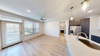 Located at 800 West Pasadena Boulevard in Deer Park, TX, this well-appointed 2-bedroom, 2-bathroom unit offers a thoughtfully designed single-floor layout. Light wood-style flooring flows throughout, complementing the clean, neutral palette found in every room.

The open-concept kitchen and dining area serves as the heart of the home, showcasing a large center island with a white quartz countertop and undermount sink, two-tone cabinetry with dark lower cabinets and white uppers, a herringbone tile backsplash, stainless steel appliances including a French door refrigerator, and stylish pendant lighting.

The living room is bright and airy, featuring a ceiling fan, natural light from large windows with outdoor views, and direct access to a private balcony. The spacious primary bedroom includes a ceiling fan, multiple closets, and windows that bring in ample natural light. Additional closet space is provided throughout, with wire-shelved walk-in closets offering generous storage.

The bathrooms are finished with dark vanity cabinetry, quartz countertops, and large mirrors. The primary bath features a glass-enclosed walk-in shower with subway tile surround. A dedicated laundry room houses a full-size washer and dryer. The hallway connects all areas with ease, completing this functional and modern floor plan.