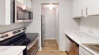 Located at 6060 Reserve Dr. in Charlotte, NC, this single-floor residence offers a well-organized layout designed for comfortable everyday living. The kitchen is equipped with a full suite of stainless steel appliances, including a smooth-top electric range, over-the-range microwave, refrigerator, and dishwasher. Marble-style countertops complement the white cabinetry, and durable wood-look flooring ties the space together with a clean, modern aesthetic.

The bedrooms are generously sized, each featuring plush carpeting and windows fitted with horizontal blinds that allow natural light to filter in while maintaining privacy. The living area also features carpet flooring and connects to the rest of the unit, with a front entry door providing direct access.

Two full bathrooms serve the unit, each outfitted with a tub/shower combination featuring white tile surrounds, standard vanities with white cabinetry, and wood-look flooring. One bathroom includes built-in wire shelving for additional storage.

Neutral gray wall tones throughout the unit provide a versatile backdrop suitable for a variety of interior styles. The overall layout is functional and cohesive, making this Charlotte residence a practical and move-in-ready space.