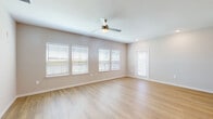 This well-appointed 3-bedroom, 2-bathroom residence at Bay Island Lane in Kissimmee, Florida offers a thoughtfully designed single-floor layout with a clean, modern aesthetic. Light wood-tone flooring flows consistently throughout, complementing the neutral warm-beige walls and bright white trim found in every room.

The open-concept kitchen and living area serves as the heart of the home, featuring white shaker-style cabinetry, a white quartz countertop, a center island ideal for dining or meal prep, and a full suite of stainless steel appliances including a refrigerator with ice maker, range, microwave, and dishwasher. Stylish pendant lighting accents the kitchen, while recessed lighting and large windows flood the living area with natural light.

The generously sized primary bedroom offers ample space, while two additional bedrooms each feature ceiling fans and windows with outdoor views of the surrounding greenery. The primary bathroom is equipped with a long vanity, white cabinetry with brushed nickel hardware, a framed mirror, and a glass-enclosed shower. The second bathroom includes a full tub-shower combo and matching white vanity. A dedicated in-unit laundry room with a full-size washer and dryer and overhead shelving adds everyday convenience to this well-rounded home.
