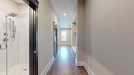 This 670 square foot single-floor residence offers a thoughtfully designed living space that maximizes functionality and style. The open-concept layout creates a sense of spaciousness, with the living room seamlessly flowing into other areas of the home. Rich, wood-look laminate flooring extends throughout, providing warmth and durability.

A standout feature is the pair of navy blue sliding barn doors, adding a modern farmhouse touch and offering flexible space division. Recessed lighting and a contemporary ceiling fan ensure balanced illumination and comfort. The walls, painted in a neutral tone, provide a clean backdrop for personalization.

The space benefits from high ceilings, enhancing the feeling of openness. A hallway leads to other rooms, likely including the bathroom and closet mentioned in the property summary. While compact at 670 square feet, the efficient design makes excellent use of the available space, creating a cozy yet uncluttered environment perfect for modern, minimalist living.