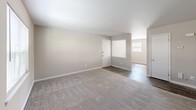 Located at 639 Archdale Dr in Charlotte, NC, this single-floor, two-bedroom, one-bathroom home offers a practical and well-organized layout. The living room provides a comfortable open area with plush carpet flooring and neutral-toned walls, transitioning seamlessly to wood-look flooring near the entryway and kitchen. Natural light filters in through multiple windows fitted with blinds, creating a bright and welcoming ambiance throughout.

The kitchen is equipped with gray cabinetry, white countertops, a double stainless steel sink, and a black dishwasher, offering ample storage and functional workspace. Wood-look tile flooring completes the kitchen's clean, modern aesthetic.

Both bedrooms feature soft carpet flooring and neutral wall tones. The spacious primary bedroom includes a closet and a window that allows natural light to brighten the room. The second bedroom is similarly appointed, with its own window and access to the hallway. 

The bathroom includes a vanity with a white countertop and an integrated tub-shower unit, finished with wood-look tile flooring and textured walls for a clean, utilitarian design. A connecting hallway ties all rooms together, contributing to the home's efficient single-floor flow.