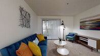 Located at 5800 Auvers Blvd in Orlando, Florida, this single-floor residence offers a well-organized layout designed for comfortable everyday living. The living room serves as the heart of the home, featuring plush wall-to-wall carpeting, vaulted-style ceilings, and a large sliding glass door dressed with vertical blinds that fills the space with natural light and provides views of the greenery outside. The open, airy feel makes it an inviting area for relaxing or entertaining. Adjacent to the living room, the dining area comfortably accommodates a round table and seating for four, with a pass-through window connecting directly to the kitchen. The kitchen is outfitted with white cabinetry, a tile backsplash, a stainless steel sink, and a full range, offering a clean and functional workspace. Both bedrooms are generously sized with soft carpeting and ample natural light from windows with blinds. Each bedroom features a walk-in or standard closet for storage. The two bathrooms are finished with white vanities, large mirrors, wood-look flooring, and tub-shower combinations, presenting a crisp, clean aesthetic throughout. The overall ambiance of the residence is bright, neutral, and move-in ready.