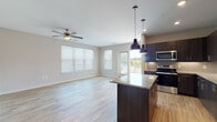 Located at 2190 Northlake Pkwy in Tucker, GA, this well-appointed 2-bedroom, 2-bathroom residence offers a thoughtfully designed single-floor layout with a seamless flow between living spaces. The open-concept living and dining area is bathed in natural light from large windows and a sliding glass door that leads to a private balcony with outdoor views. Light wood-style flooring runs throughout the main living areas, complemented by a ceiling fan overhead.

The gourmet kitchen is a standout feature, showcasing rich dark-wood cabinetry extending to the ceiling, granite countertops, a textured tile backsplash, and a center island with pendant lighting. A full suite of stainless steel appliances—including a refrigerator, electric range, microwave, and dishwasher—completes the space.

Both bedrooms are carpeted and include ceiling fans and windows that allow ample natural light. The bathrooms mirror the kitchen's design aesthetic with dark cabinetry and granite countertops, and wood-style tile flooring. Each bedroom is served by a walk-in closet equipped with wire shelving systems, offering generous storage capacity. Additional hallway storage and a well-organized layout further enhance the functional design of this residence.