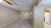 Located at 4980 Sean Haggerty Dr in El Paso, TX, this single-story, 2-bedroom, 1-bathroom home offers a practical and well-organized layout. Light beige tile flooring runs consistently throughout the entire home, providing a clean, cohesive look. The combined living and dining area forms the heart of the home, featuring a textured ceiling, a pendant light fixture, and a ceiling fan, creating a comfortable and functional shared space. The galley-style kitchen is efficiently designed with warm wood cabinetry, dark countertops, and white appliances including a gas range, dishwasher, and microwave. A dedicated pantry adds valuable storage. Both bedrooms are well-proportioned, each featuring a ceiling fan, natural light from windows with blinds, and generous closet space — the primary bedroom notably includes two side-by-side closets with built-in shelving and hanging rods. The full bathroom is equipped with a tub-shower combination with a curtain, a wood vanity with a single sink, a lighted mirror, and a window that brings in natural light. The home also includes a dedicated laundry area and hallway, rounding out a thoughtful and complete floor plan.