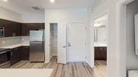 Located at 8707-8747 Fletcher Pkwy in La Mesa, California, this single-floor residence offers a thoughtfully designed layout with modern finishes throughout. The open living area features wood-style laminate flooring in a cool gray tone, recessed lighting, and a ceiling fan, creating a bright and comfortable atmosphere. A sliding glass door invites natural light and provides access to an outdoor view of lush greenery.

The kitchen is outfitted with rich dark espresso cabinetry, stainless steel appliances including a range, over-the-range microwave, and refrigerator, all complemented by crisp white countertops and a classic subway tile backsplash. An adjacent pantry closet provides additional storage, while the layout connects seamlessly to the main living space.

The bedroom is carpeted for comfort and features a ceiling fan and a window overlooking treetop views, filling the room with soft natural light. The bathroom is clean and functional, with dark cabinetry matching the kitchen aesthetic, white countertops, and a full tub-shower combination with a curved curtain rod. Wood-style flooring continues into the bathroom, maintaining a cohesive design throughout. A dedicated entryway provides a welcoming transition into the home, completing this well-appointed residence.