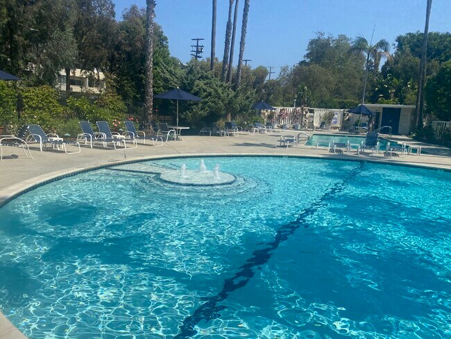 Resort style pool with fountain, lounge chairs, saltwater pool and spa, bathrooms and changing rooms - 241 S Barrington Ave