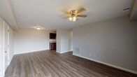 Located at Wolf Run Park in Jeffersonville, Indiana, this single-floor residence offers a clean, modern aesthetic with consistent wood-style flooring throughout. The open living area is spacious and inviting, highlighted by a ceiling fan with light fixture, neutral-toned walls, and a seamless connection to the kitchen. Natural light filters in through windows fitted with blinds, enhancing the bright and airy atmosphere.

The kitchen is well-equipped and functional, featuring rich dark cabinetry, granite-style countertops, a stainless steel sink with a modern pull-down faucet, and a full suite of stainless steel appliances including a refrigerator, dishwasher, microwave, and range. Recessed lighting illuminates the space efficiently.

The bedrooms continue the wood-style flooring and neutral color palette, offering versatile layouts with adequate natural light. Each room provides a calm, comfortable environment suitable for a variety of uses.

The bathrooms mirror the design consistency of the rest of the unit, each equipped with a dark vanity topped with granite-style countertops, a combined tub and shower unit, and wood-style flooring. Clean white finishes and ample space make these rooms both practical and attractive. Overall, the space presents a cohesive, contemporary living environment.