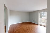 Located at 8950 Wyandotte St E in Windsor, Ontario, this one-bedroom, one-bathroom unit offers a practical and well-organized layout across a single floor. Warm hardwood flooring flows consistently throughout the space, lending a cohesive and inviting feel to each room.

The entryway hallway leads into a bright, open living room bathed in natural light from a large sliding glass door that opens directly onto a private balcony, offering views of the surrounding neighbourhood. A wall-mounted baseboard heater ensures year-round comfort.

The kitchen is efficiently designed with clean white cabinetry, a stainless steel sink with grey countertops, and a full-size refrigerator, providing ample functionality within a compact footprint. Hardwood flooring continues seamlessly from the main living areas into the kitchen.

The bedroom is a comfortable and quiet retreat, featuring a sliding window with an outdoor view and a baseboard heater along the wall. Neutral grey tones throughout the room create a calm atmosphere.

The bathroom features a tiled tub-shower combination with crisp white subway-style tiles, maintaining a clean and simple aesthetic.

Overall, this unit presents a straightforward, functional living space with consistent finishes, good natural light, and the added benefit of private outdoor access via the balcony.