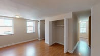 Located at 202 in the 63112 zip code of St. Louis, Missouri, this single-floor unit offers a functional and well-maintained layout designed for comfortable everyday living. Throughout the space, warm hardwood-style flooring flows consistently, complemented by neutral beige walls and clean white trim that create a bright, cohesive aesthetic.

The living area is notably spacious, with a private entry door and an open feel enhanced by abundant natural light. A sun-filled corner room features multiple large windows overlooking mature, leafy trees, providing a peaceful and verdant outdoor view that brings life into the interior.

The bedroom is generously proportioned, accommodating a range of furniture arrangements with ease. It includes a dedicated closet with bifold doors, a built-in hanging rod, and ample storage space. Windows in the bedroom allow natural light to filter in, adding to the room's airy quality.

The kitchen is well-appointed with warm wood cabinetry, dark granite-style countertops, a stainless steel sink, and black appliances including a dishwasher and range. Upper and lower cabinets provide practical storage throughout.

The bathroom features a full tub and shower combination with clean white subway-style tile surround, chrome fixtures, and neutral tile flooring, offering a simple and functional design.