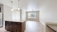 Located at 9580 RidgeGate Parkway in Lone Tree, CO, this well-appointed one-bedroom, one-bathroom residence offers a thoughtfully designed single-level floor plan with a comfortable and functional layout. The open-concept kitchen and living area serves as the heart of the home, featuring light hardwood-style flooring, track and pendant lighting, and a central island topped with granite countertops. The kitchen is equipped with rich dark wood cabinetry, stainless steel appliances including a refrigerator, range, and microwave, and a classic subway tile backsplash that adds a clean, modern touch. The living area flows naturally from the kitchen, providing a versatile and welcoming space. The bedroom is carpeted for comfort and is illuminated by natural light through a window fitted with blinds, complemented by a ceiling fan. It includes access to a dedicated walk-in closet with built-in hanging storage. The bathroom features a granite-topped vanity with dark wood cabinetry, a tiled tub-shower combination, and hardwood-style flooring consistent with the rest of the unit. Neutral warm-toned walls throughout create a cohesive and inviting ambiance, making this Lone Tree residence a practical and attractive living space.