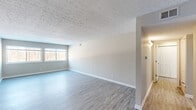 Located at 9400 Hurstbourne Park Boulevard in Louisville, KY, this one-bedroom, two-bathroom residence offers a well-designed single-floor layout with a thoughtful mix of comfort and functionality. The open living and dining area is bright and welcoming, featuring light-toned luxury vinyl plank flooring and a textured ceiling that adds visual character. A window lets in natural light, enhancing the airy, neutral color palette throughout. The kitchen is well-appointed with crisp white shaker cabinetry, marble-look countertops, and black appliances including a refrigerator, electric range, and dishwasher — offering both style and practicality. The spacious primary bedroom features plush wall-to-wall carpeting, a ceiling fan with light fixture, and a window with outdoor views, creating a restful retreat. The two bathrooms are clean and functional, with one featuring a tiled tub-shower combination with chrome fixtures. Throughout the residence, six closets provide exceptional storage capacity. Additional areas finished in light vinyl plank flooring offer flexible use as a dining space or additional living area. The overall ambiance is clean, modern, and move-in ready, making it an ideal home in the Hurstbourne Park community.